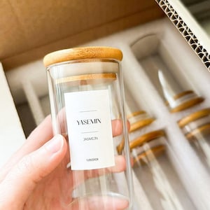May include: A clear glass jar with a bamboo lid and a white label that reads "YASEMIN JASMİJN TÜRKSEKÖK".