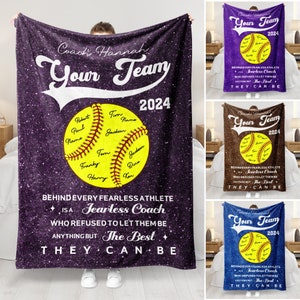 May include: A purple fleece blanket featuring a softball design with the text "Coach Hannah Your Team 2024". The softball has names written on it. The text "Behind every fearless athlete is a fearless coach who refused to let them be anything but the best they can be" is also on the blanket.