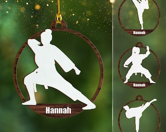 May include: Three wooden Christmas ornaments featuring a white silhouette of a person in a karate pose. Each ornament has the name "Hannah" written on it.