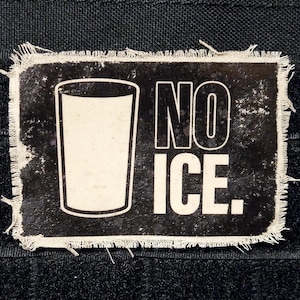 May include: A rectangular patch with a distressed black background and white text and graphics. The patch features a glass graphic and the words "NO ICE." The edges are frayed.
