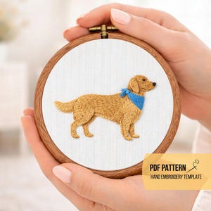 May include: Hand embroidery hoop art featuring a golden retriever dog with a blue bandana. The dog is embroidered in shades of tan and brown on white fabric, set in a wooden hoop. Text on the image reads "PDF PATTERN HAND EMBROIDERY TEMPLATE."