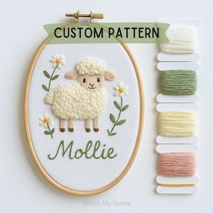May include: An embroidered oval hoop art piece featuring a sheep with the name "Mollie" in green script. The artwork includes daisies and the text "CUSTOM PATTERN". Spools of thread in various colors are visible.