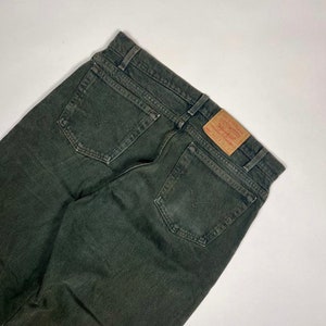 Op de afbeelding: Een donkergroene spijkerbroek met een bruine leren Levi's-patch op de achterzak.
