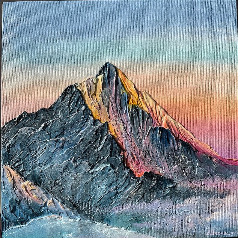 May include: Textured oil painting of a mountain range at sunset. The mountain is a dark gray with yellow and pink highlights. The sky transitions from light blue to orange and pink. The painting is signed in the bottom right corner.