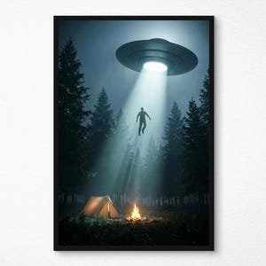 May include: A framed art print showing a forest at night with a UFO overhead. A person is being lifted by a beam of light from the UFO. A campfire and tent are in the foreground, with tall trees in the background, creating a mysterious atmosphere.