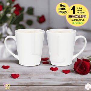 May include: Two white 12oz latte mugs with a light brown liquid inside, sitting on a wooden surface with red hearts scattered around them. A red rose is in the background.