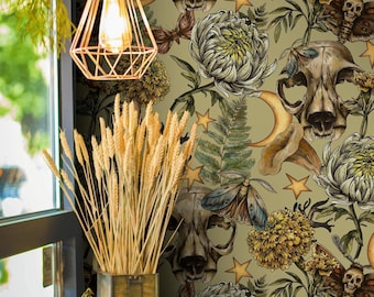 May include: A decorative wallpaper featuring a repeating pattern of animal skulls, moths, flowers, stars, and moons in shades of beige, brown, and green. The image also includes a copper-colored geometric light fixture and a vase of wheat.