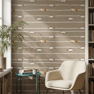 May include: A wall covered in wallpaper with a repeating pattern of fish. The fish are in black and white, with some featuring orange accents. Horizontal white stripes separate the fish. A beige chair and small table are in front of the wall.