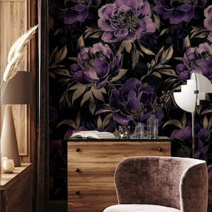 May include: A room featuring a floral wallpaper with large purple flowers and gold accents. A wooden dresser, a velvet armchair, and a modern lamp are in the room. The wallpaper creates a dramatic and elegant atmosphere.