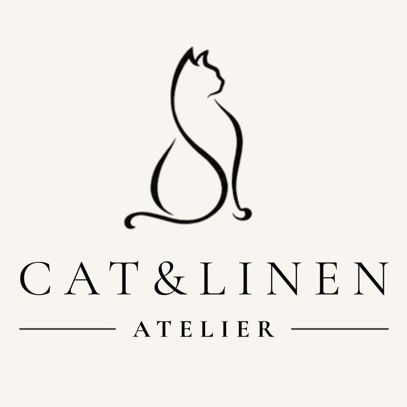 K&ouml;nnte beinhalten: Eine schwarze Strichzeichnung einer sitzenden Katzensilhouette &uuml;ber dem Text CAT & LINEN in Serifenschrift, mit dem Wort ATELIER darunter zentriert zwischen zwei horizontalen Linien auf einem hellen cremefarbenen Hintergrund.