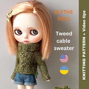 May include: A Blythe doll wearing a green tweed cable knit sweater. The doll has blonde hair and blue eyes. The image includes the text "Blythe Doll", "Tweed cable sweater", and "Knitting Pattern + Video tips". The text is in orange and the background is green.