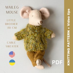 May include: A knitted cable sweater for a Maileg mouse doll. The sweater is green with a brown cable pattern. The mouse doll is wearing the sweater and brown pants. The doll is 10 cm tall. The image also includes the text "Knitting Pattern + Video tips" and "PDF".