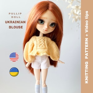 May include: A yellow knitted blouse for a doll, with a ruffled hem. The doll is wearing the blouse and white shorts. The image also includes the text "PULLIP DOLL UKRAINIAN BLOUSE" and the flags of the United States and Ukraine.