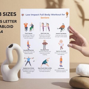 May include: A white poster titled "Low Impact Full Body Workout for Seniors" with exercise illustrations. The poster is held by a hand, and lists the sizes: US Letter, Tabloid, and A4. A white ceramic vase and a stone are in the foreground.