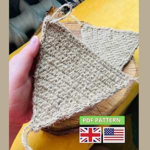 Puede incluir: Un triángulo tejido a crochet hecho de hilo de fibra natural, con un borde deshilachado. El triángulo se sostiene en una mano, y el fondo es una superficie amarilla. El texto "PDF PATTERN" es visible en letras verdes, junto con las banderas del Reino Unido y los Estados Unidos.