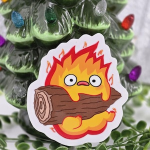 May include: A yellow and orange cartoon fire spirit with a surprised expression, holding a brown log in its arms. The fire spirit is surrounded by flames.