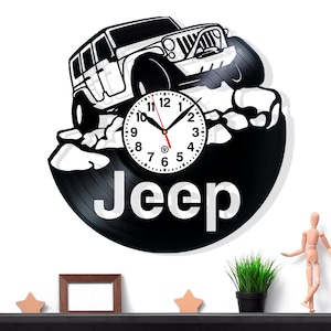 May include: Black and white Jeep-themed wall clock. The clock features a Jeep vehicle design and the word "Jeep" in large white letters. The clock hands are black and red.
