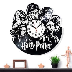 May include: Black vinyl record clock featuring characters from the Harry Potter series. The clock face is white with black numbers and hands. The words "Harry Potter" are written in a stylized font below the clock.