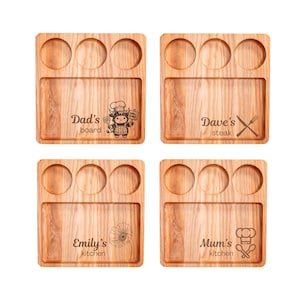 Puede incluir: Cuatro tablas de servir de madera con veta natural. Cada tabla tiene tres hendiduras circulares y una sección rectangular. El texto y los gráficos incluyen "Dad's board", "Dave's steak", "Emily's kitchen" y "Mum's kitchen".