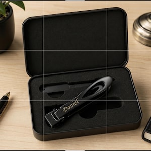 May include: A black metal nail clipper set featuring the name Daniel engraved in gold lettering on the handle. The set is housed in a black rectangular metal storage case with a custom-fitted black foam insert that holds the clipper securely.