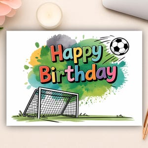 May include: A birthday card with a football theme. The card displays the words "Happy Birthday" in colourful letters, a football, and a goal. The background features watercolour-style paint splatters.