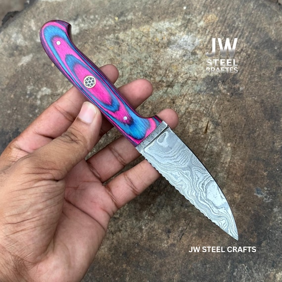 Hand-forged Damascus steel with a swirling water pattern blade paired with an unexpected pink Pakka wood handle — a blade that's actually a visual statement piece.