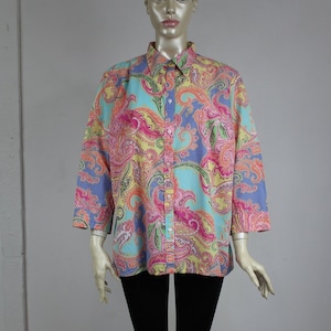 May include: A long-sleeved button-down shirt with a colorful paisley print. The shirt is light blue, pink, yellow, and green.