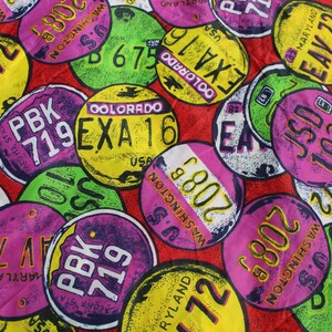 May include: A colorful fabric pattern featuring various license plates with different state names and abbreviations, including Maryland, Colorado, Washington, and New York. The plates are in various colors, including pink, green, yellow, and blue.