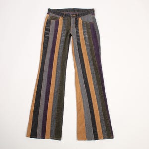 May include: Full-length trousers featuring a vertical striped pattern in alternating shades of tan, dark gray, and deep purple. These pants have a classic waistband with a button closure, a front zipper fly, and two front pockets, with a flared leg cut.