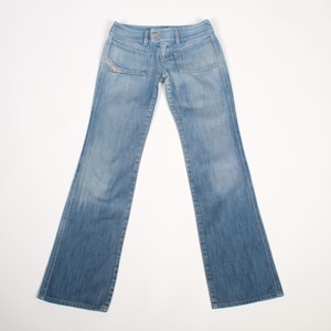 May include: Light blue denim jeans featuring a low-rise waist, a button and zipper fly closure, and two front pockets. The jeans have a slight flare at the leg openings and a small red logo tag on the right front pocket area, showcasing a faded wash.