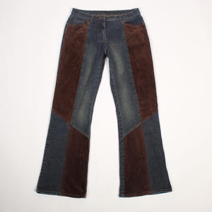 May include: Blue denim jeans featuring dark brown corduroy panels along the outer legs. These pants have a standard waistband with a button and zipper fly closure, front pockets, and a straight-leg cut with a slight flare toward the bottom hem.
