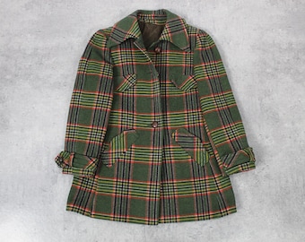 Puede incluir: Una chaqueta de cuadros verdes, rojos y amarillos con cierre de botones y mangas largas. La chaqueta tiene dos bolsillos de solapa en la parte delantera y un cuello.