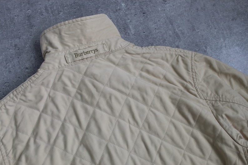 May include: A beige quilted jacket with a Burberrys label on the back.