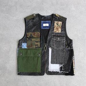 May include: Black leather vest with multiple pockets and patches in various colors and patterns, including camouflage and denim. The vest has a zipper closure and a unique, patchwork design. The vest is a size medium.