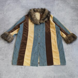 May include: A vintage coat with a striking striped design in blue, brown, and yellow. The coat features a faux fur collar and cuffs, and a button-down front. The garment is laid flat on a grey surface.
