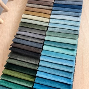 May include: A fabric swatch book with a variety of colors, including green, blue, brown, and beige. The book is labeled "Matt Atelier, Specially Made."