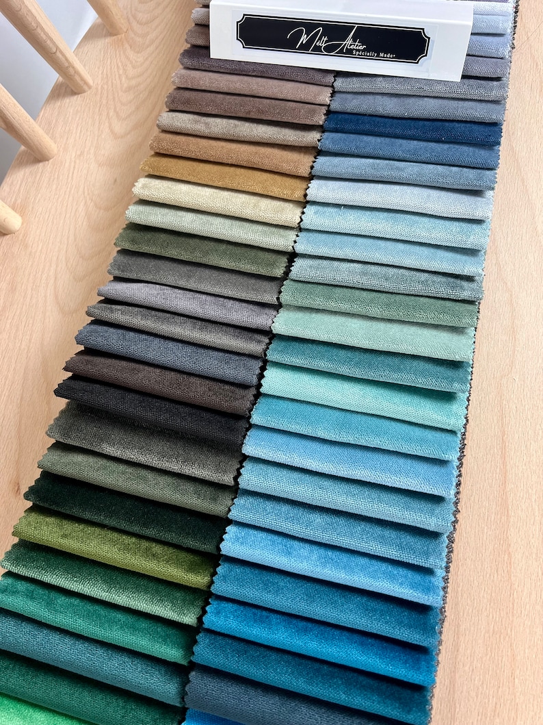 May include: A fabric swatch book with a variety of colors, including green, blue, brown, and beige. The book is labeled "Matt Atelier, Specially Made."