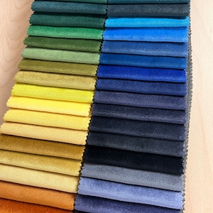 May include: A fabric swatch book with a variety of colors, including green, blue, yellow, orange, and brown. The book is labeled "Matt Atelier, Specially Made."