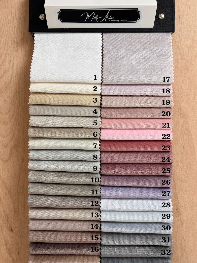 May include: A fabric swatch book with 32 different fabric samples. The swatches are arranged in two columns, with numbers 1-16 on the left and 17-32 on the right. The fabrics range in color from white to gray to pink to purple.