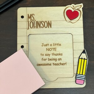 May include: A wooden teacher appreciation frame with a red apple and a pencil. The frame has a space for a note and says "MS. JOHNSON" and "Just a little NOTE to say thanks for being an awesome teacher!"