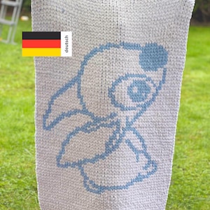 May include: A white knitted baby blanket with a blue embroidered design of a cartoon character. The character has a large head with a single eye and a small body.
