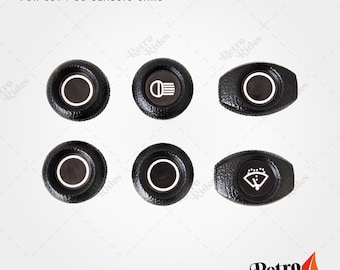 May include: Six black plastic dashboard knobs with white accents. The knobs feature different symbols, including a headlight, a windshield wiper, and a circle.