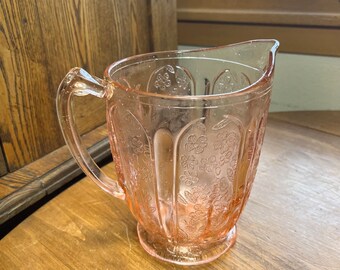 Vintage Jeanette Pink Depression Glass Cherry Blossoms Pitcher 7 Inch. Has a chip at the base as pictured.  Please inspect photos before pur