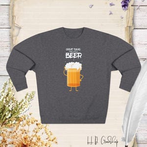 May include: A dark gray sweatshirt with a white graphic of a beer glass with the text "Great Ideas Start With A Beer".