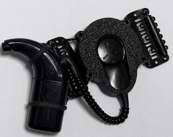 May include: A black hearing aid retention device featuring a smooth, curved earpiece connected by a coiled cord to a textured, circular housing unit. The unit includes a flat, rectangular clip with multiple small teeth for secure attachment.