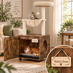 May include: A rustic brown wooden cat house with a hinged door and a side cutout, featuring a plush beige cat tree on top with a hanging toy. Inside, a ginger cat rests on a striped cushion. A small wooden sign reads Bella's Home with a paw print.