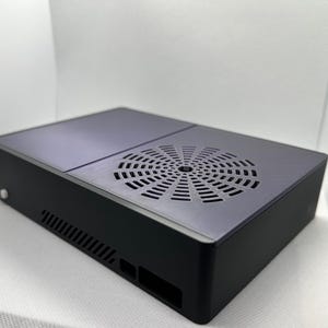 Può includere: Un case per computer rettangolare nero con una griglia di ventilazione sulla parte superiore. Il case ha un design elegante e moderno.