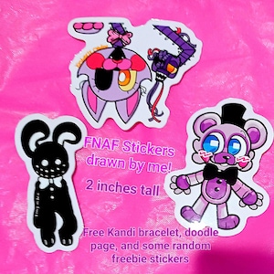 May include: A set of four FNAF stickers featuring characters from the popular video game series. The stickers are printed on white vinyl and are 2 inches tall. The text "FNAF Stickers drawn by me! 2 inches tall" is printed on a white background. The stickers are displayed on a pink surface.