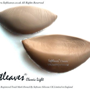 Op de afbeelding: Twee paar huidkleurige siliconen bh-inlegstukken. Het bovenste paar is gelabeld met "Softleaves Classic UK[lot99] 67111 M". Het onderste paar is gelabeld met "Softleaves (R) Classic Light".