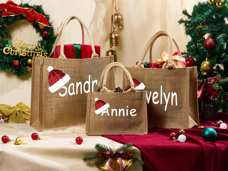 May include: Three burlap tote bags with white text and Santa hats. The bags are personalized with the names Sandra, Annie, and Velyn. The bags are filled with gifts and are set against a Christmas background.